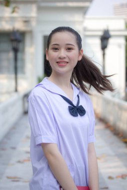 Asya Thai ortaokulu öğrencisi üniforması güzel kız gülümse ve rahatla