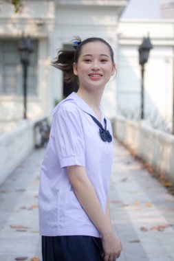 Asya Thai ortaokulu öğrencisi üniforması güzel kız gülümse ve rahatla