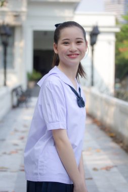 Asya Thai ortaokulu öğrencisi üniforması güzel kız gülümse ve rahatla
