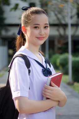 Asya Thai ortaokulu öğrencisi üniforması güzel kız gülümse ve rahatla
