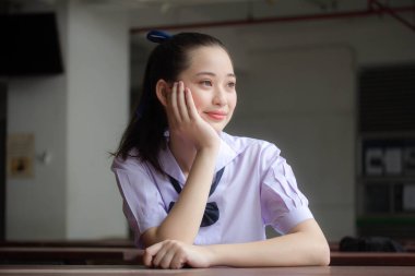 Asya Thai ortaokulu öğrencisi üniforması güzel kız gülümse ve rahatla