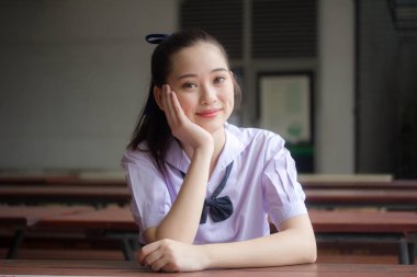 Asya Thai ortaokulu öğrencisi üniforması güzel kız gülümse ve rahatla