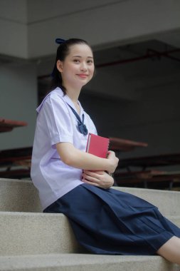 Asya Thai ortaokulu öğrencisi üniforması güzel kız gülümse ve rahatla