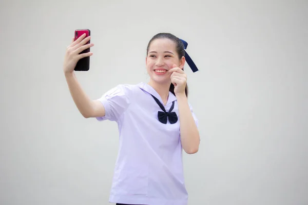 그녀의 스마트폰 셀피를 사용하여 아름다운 제복을 주니어 고등학생의 — 스톡 사진