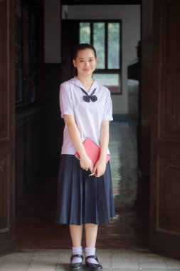 Asya Thai ortaokulu öğrencisi üniforması güzel kız gülümse ve rahatla