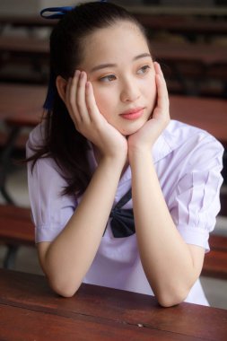 Asya Thai ortaokulu öğrencisi üniforması güzel kız gülümse ve rahatla