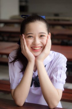 Asya Thai ortaokulu öğrencisi üniforması güzel kız gülümse ve rahatla