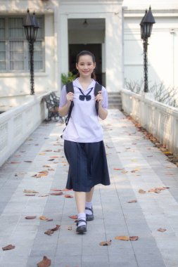 Asya Thai ortaokulu öğrencisi üniforması güzel kız gülümse ve rahatla