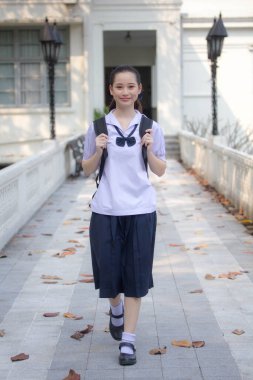 Asya Thai ortaokulu öğrencisi üniforması güzel kız gülümse ve rahatla