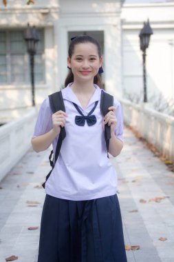 Asya Thai ortaokulu öğrencisi üniforması güzel kız gülümse ve rahatla