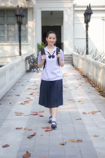 Asya Thai ortaokulu öğrencisi üniforması güzel kız gülümse ve rahatla