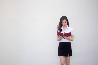 Taylandlı yetişkin üniversite üniforması güzel kız bir kitap okudu.