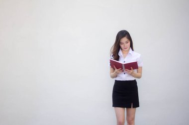 Taylandlı yetişkin üniversite üniforması güzel kız bir kitap okudu.