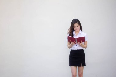 Taylandlı yetişkin üniversite üniforması güzel kız bir kitap okudu.
