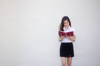 Taylandlı yetişkin üniversite üniforması güzel kız bir kitap okudu.