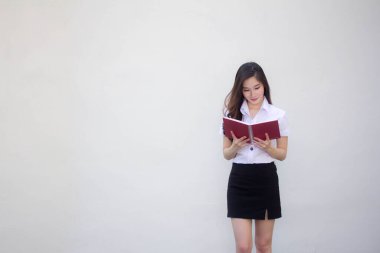 Taylandlı yetişkin üniversite üniforması güzel kız bir kitap okudu.