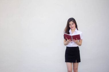 Taylandlı yetişkin üniversite üniforması güzel kız bir kitap okudu.