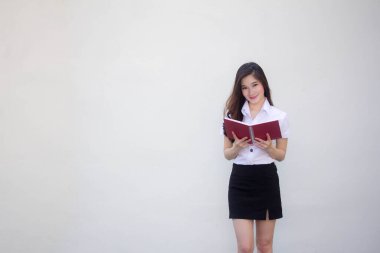 Taylandlı yetişkin üniversite üniforması güzel kız bir kitap okudu.