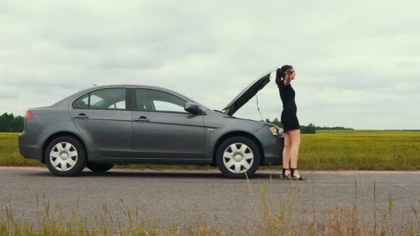 Młoda Dziewczyna Krótkiej Sukience Pobliżu Zepsutego Samochodu Próbuje Zatrzymać Samochód — Wideo stockowe