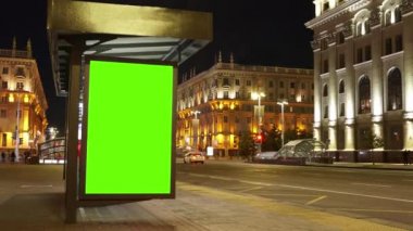 Gece otobüs durağında üzerinde krom tuşlu yeşil ekran olan ilan panosu. Zaman Süreleri.