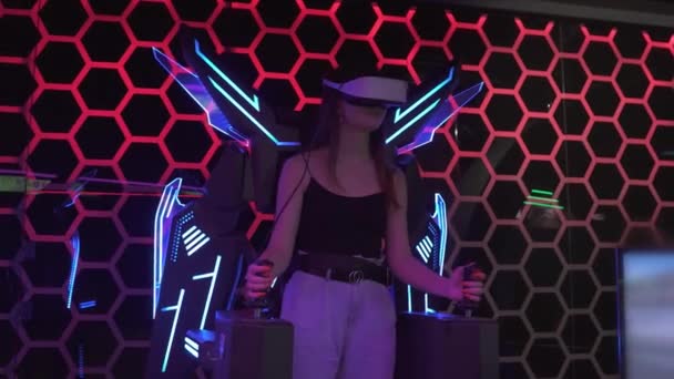 Jolie fille blanche jouant avec un jeu vidéo simulateur, elle porte un casque de réalité virtuelle. Concept futur de technologie et de divertissement. 