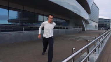 Parmaklıkları kullanarak parkour egzersizleri yapan genç bir koşucu. Şehir merkezinde parkur yapıyor..