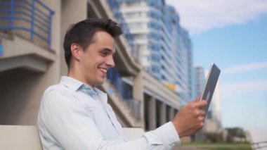 Tabletli çekici bir genç şehirde video çekiyor..