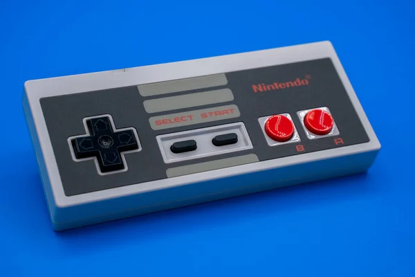 Nintendo NES denetleyici. Renkli mavi arkaplanı olan klasik oyun alanının yakın çekimi. Malaga, İspanya - 4 Haziran 2020