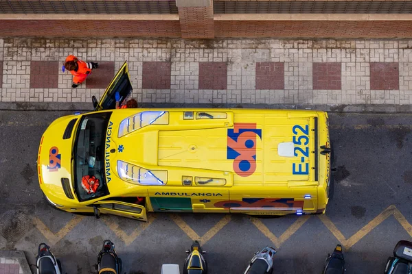 Ambulans sokağın ortasında duruyor ve hemşireler koronavirüs salgını sırasında acil bir tıbbi duruma katılıyorlar. Üst Manzara. Malaga, İspanya - 17 Temmuz 2020.
