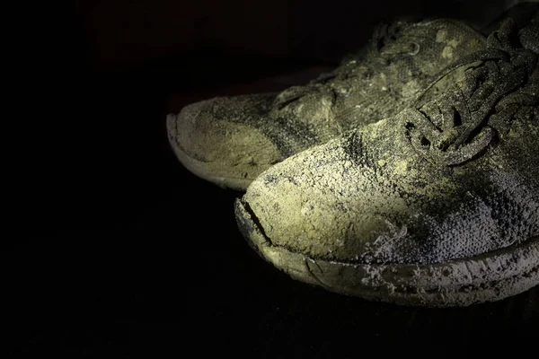 Siyah arka planda yırtık eski kirli spor ayakkabılar. izole et