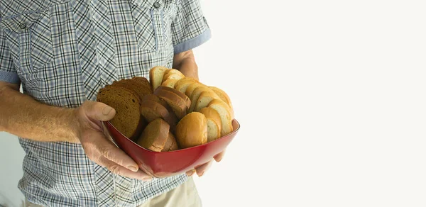 Yaşlı adam beyaz arka planda siyah beyaz ekmek tabağı tutuyor..