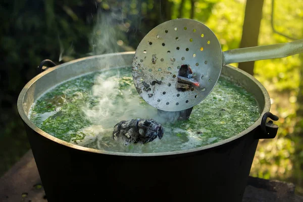 Slotted kaşık ile balık çorbasına kömür koy ve doğada kaynasın..