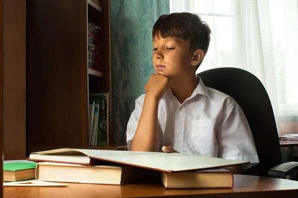Öğrenci masada oturur ve dersler öğrenir..