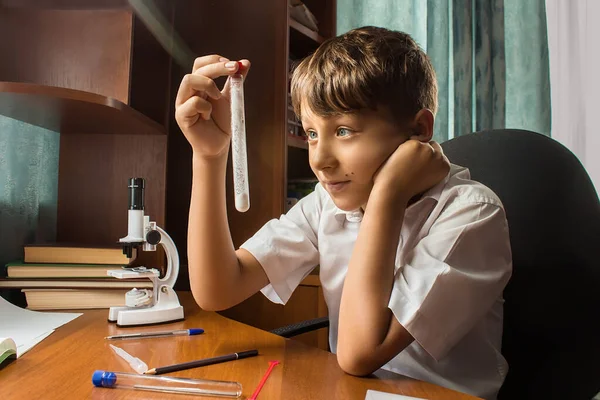 Çocuk evde kimyasal deneyler yapıyor. Elinde bir matara vardı..