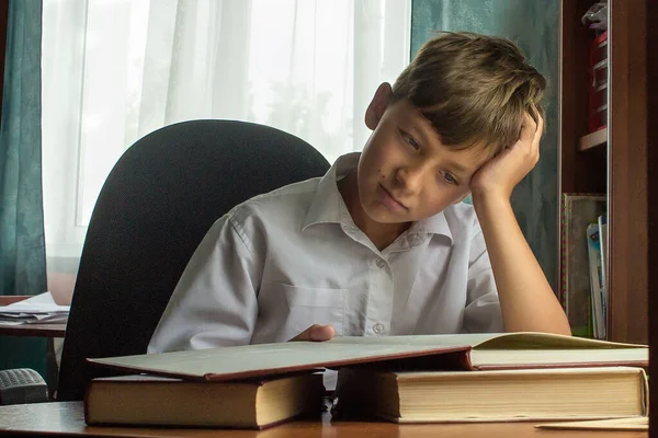 eğitim, çocukluk, insanlar, ev ödevi ve okul konsepti - evde kitap okuyan sıkıcı öğrenci çocuk.