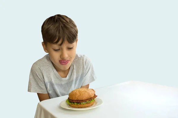 Jonge Jongen Likt Zijn Lippen Kijkt Naar Hamburger Een Lichte — Stockfoto