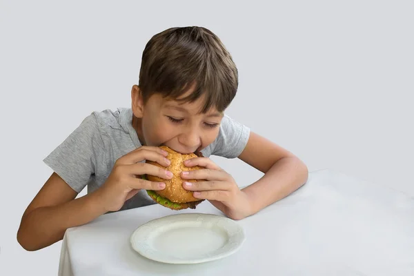 Anak Itu Makan Hamburger Terisolasi Pada Latar Belakang Putih — Stok Foto