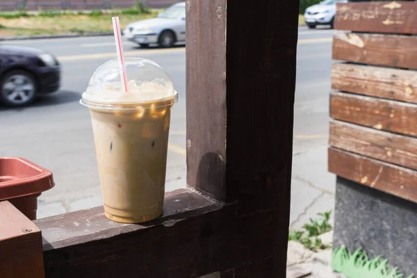 ice coffee takeaway cup on the background of a city street.