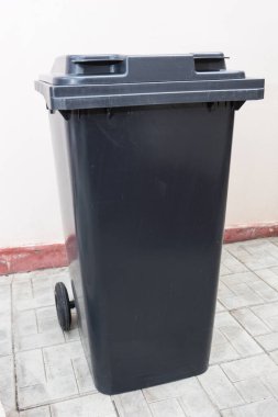 Duvarın yanındaki çöp tenekesini kapat.