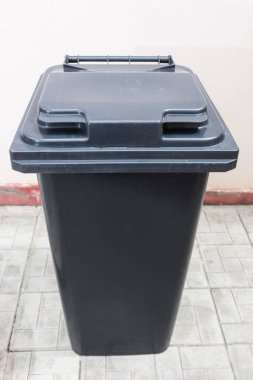 Duvarın yanındaki çöp tenekesini kapat.