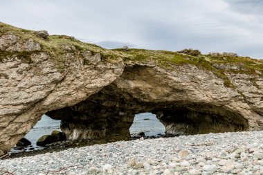 Sea stacks and caves at low tide. Arches Provincial Park, Newfoundland, Canada clipart