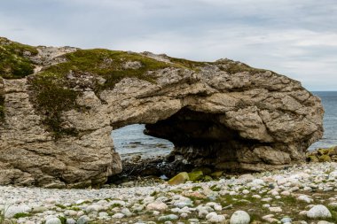 Dalgalar çekildiğinde deniz yığınları ve mağaralar. Arches Provincial Park, Newfoundland, Kanada