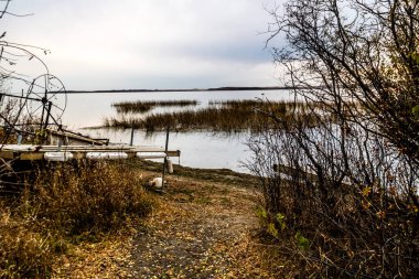Gölün etrafındaki sonbahar renklerinde güneş batıyor. Battleford İl Parkı, Saskatchewan, Kanada