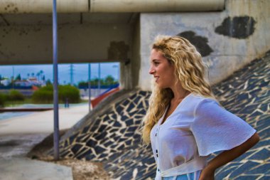 Sarışın kız parkta eğleniyor ve poz veriyor