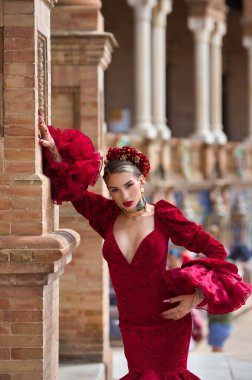 İspanya, Seville 'de bir meydanda, tuğla bir sütuna yaslanmış flamenko dansı yapan güzel bir kadın. O, kırmızı bir fırfırlı elbise giyiyor. Flamenko, insanlığın kültürel mirası.