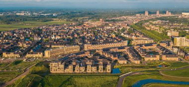 Vathorst 'un Amersfoort, Hollanda' daki günbatımı manzarası. Kanalları, yeşil alanları ve Hollanda çatıları olan modern yerleşim alanı..