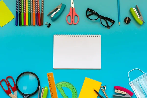 School supplies on the blue background with copy space. Back to school.
