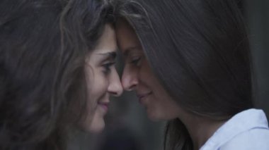 Lezbiyen kızlar birbirlerinin gözlerinin içine bakıp öpüşürler. LGBT