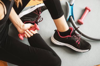 Spor ayakkabısı ve dambılı genç bir kızın üst ya da düz görüntüsü. Kopya alanı olan bir arkaplan. Sağlıklı konsept.