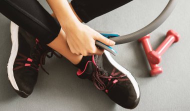 Spor ayakkabısı ve dambılı genç bir kızın üst ya da düz görüntüsü. Sağlıklı konsept.